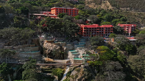 tolantongo mexico aerial v13 establishing drone fly around hillside hot springs resort, nature oasis with warm thermal pools and adventurous suspension bridge - shot with mavic 3 cine - december 2021