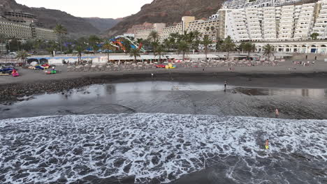 Luftaufnahme-In-Einem-Kreis-Am-Ufer-Des-Taurito-Strandes-In-Mogan,-Wo-Man-Menschen-Beim-Baden-Sehen-Kann