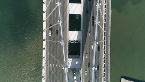 Aerial-shot-of-vehicles-moving-on-San-Francisco–Oakland-Bay-Bridge-with-city-in-background