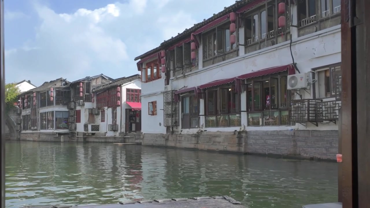 Çin'in Şanghay şehrindeki Zhujiajiao antik su kasabasında, tarihi binalarla çevrili bir kanalın 4K videosu.