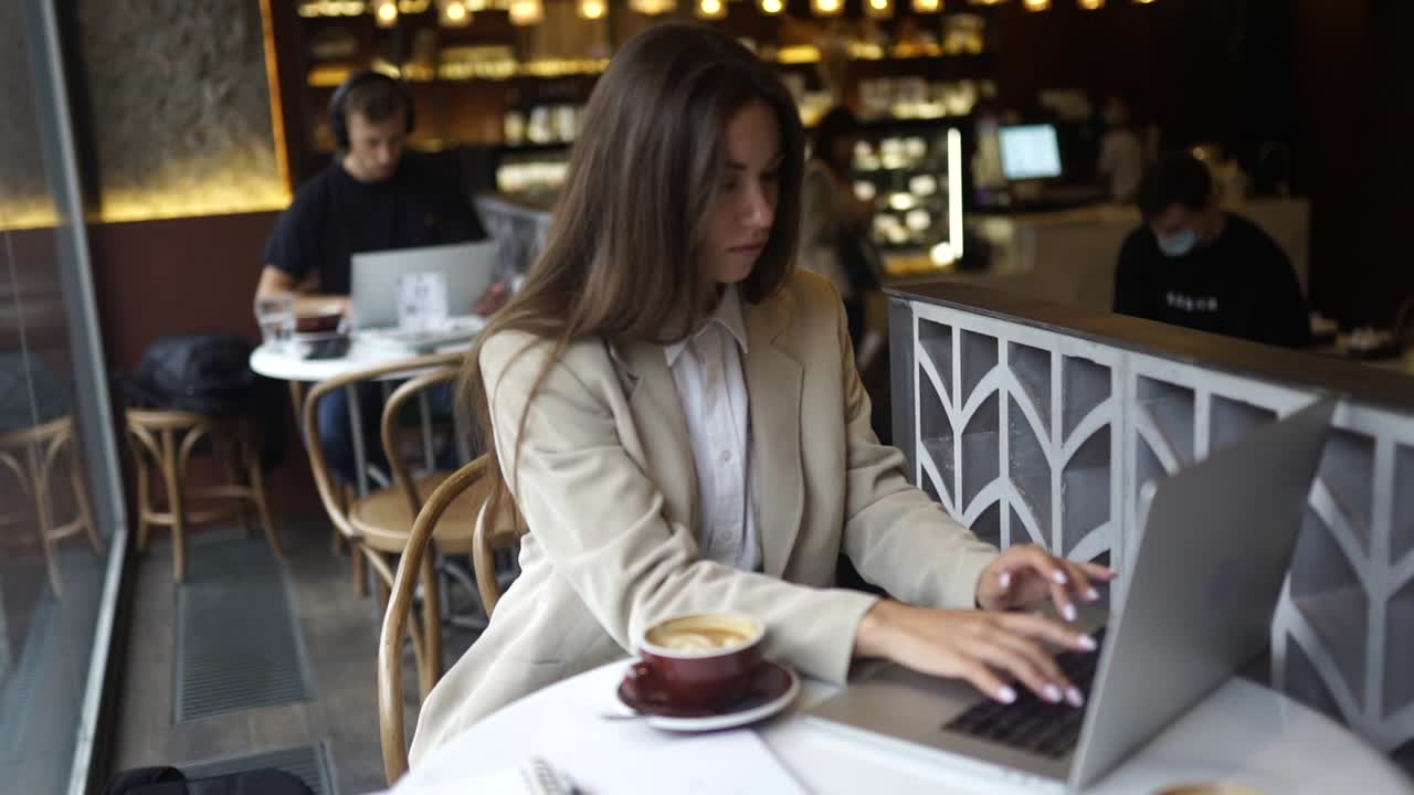 Una donna che lavora su un portatile in un caffè