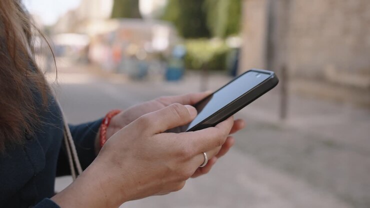 Mani femminili che digitano tranquillamente per strada