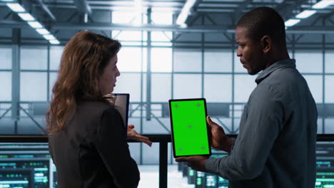 developers in data center using mockup tablet, observing performance analytics