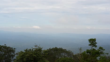 Nubes-Lentas,-Delgadas-Y-De-Colores-Pastosos-Que-Se-Mueven-Hacia-La-Izquierda-Y-Ruedan-Arriba-En-Un-Paisaje-Del-Parque-Nacional-Timelapse-Khao-Yai,-Tailandia