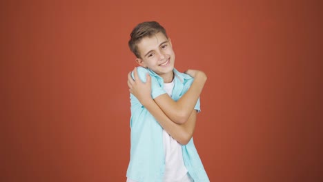 el chico abraza la cámara.