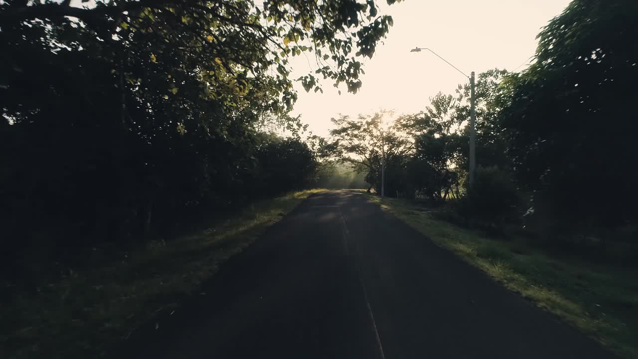 imágenes de drones al revés de una carretera durante un amanecer dorado