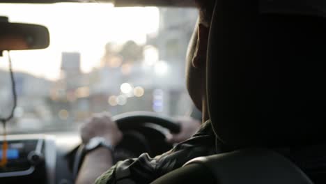 man-hold-car's-wheel-steering-while-driving-a-car-in-sunset-time