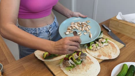 mujer preparando envolturas de pollo