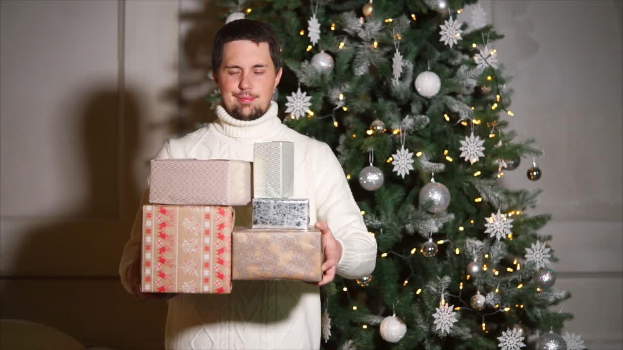 Man with Christmas Presents in front of a Christmas Tree