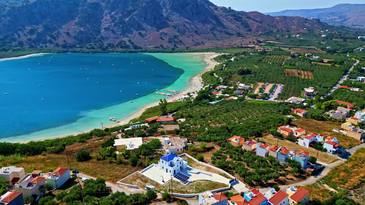 Vysoký panoramatický letecký pohled na jezero Kournas s vesnicí a okolními horami.