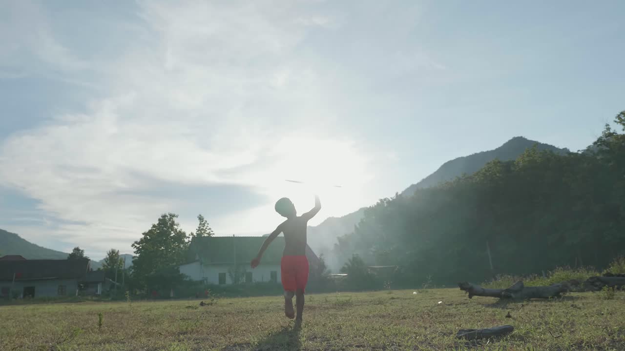 A Boy Playing with a Toy Airplane in a Rural Setting