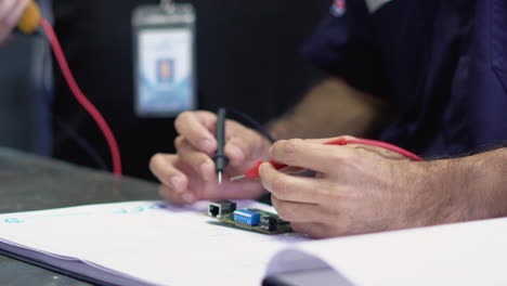 un obrero soldando meticulosamente un chip con una herramienta de soldadura, mostrando precisión y experiencia