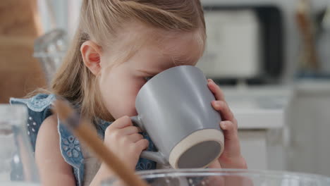 Niña-Divertida-Bebiendo-Chocolate-Caliente-En-La-Cocina-Disfrutando-De-Un-Delicioso-Manjar-En-Casa-Después-De-Hornear-En-La-Cocina-4k