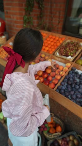 woman shopping for fruits at a farmers market