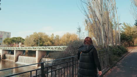 A-Girl-is-walking-and-looking-at-the-waterfall-under-the-bridge,-Montpellier---France