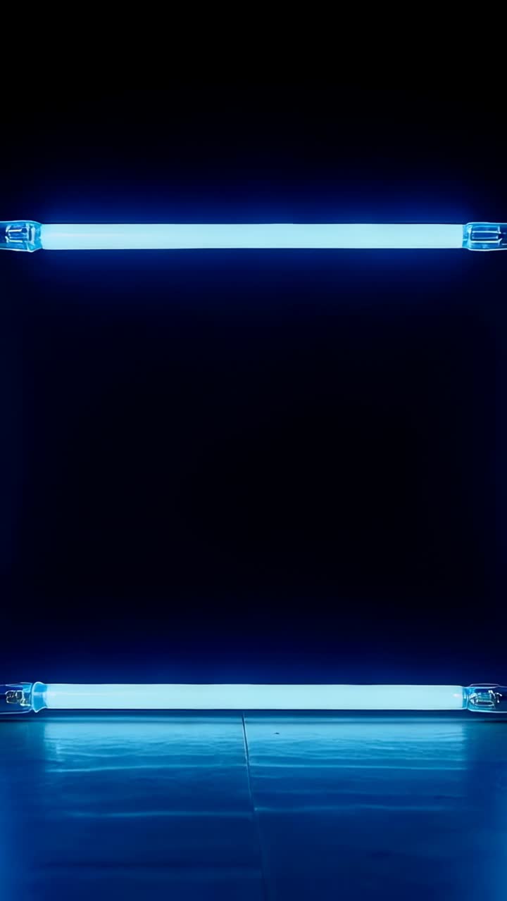 Vertical video: Framing two horizontal blue tubes on dark set, floor reflecting while dimming