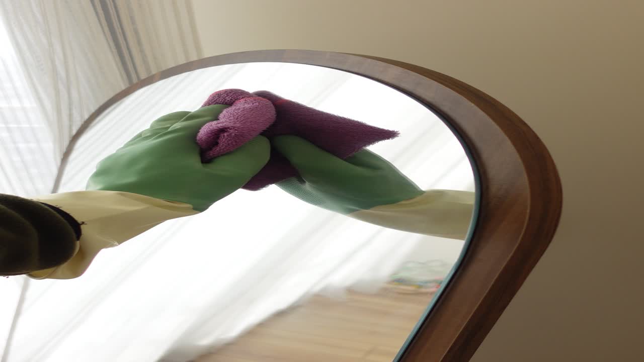 limpiando un espejo con guantes