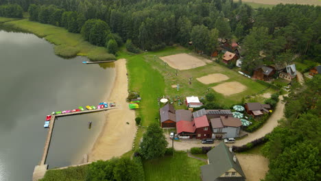 vista aérea del lago hartowiec con playa de arena y casas en polonia