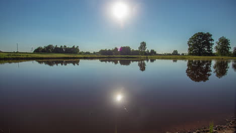 Lapso-De-Tiempo-Fresco-De-La-Puesta-Del-Sol-Y-Luego-Saliendo-Detrás-De-Los-árboles-En-Un-Día-De-Verano-Y-Un-Lago-Tranquilo-Que-Refleja-Todo