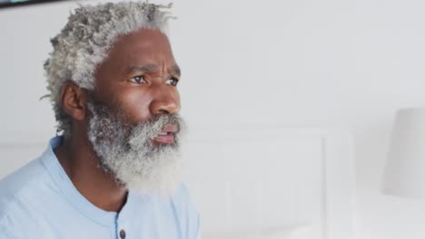 senior man sitting on bed at home