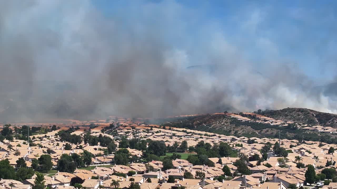 Grande incendio nell'area naturale di San Jacinto sulla comunità di Sun Lakes a Banning, California, con fuoco vicino alle case. RIPRESA AEREA STATICA.