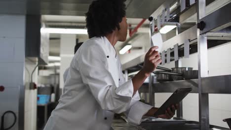 chef afroamericana tomando pedidos en la cocina del restaurante