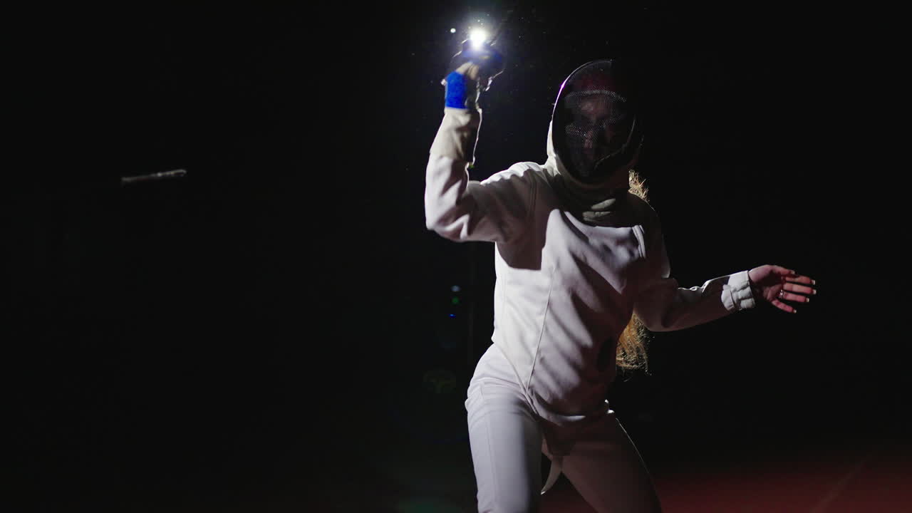 A female fencer in action during a fencing match
