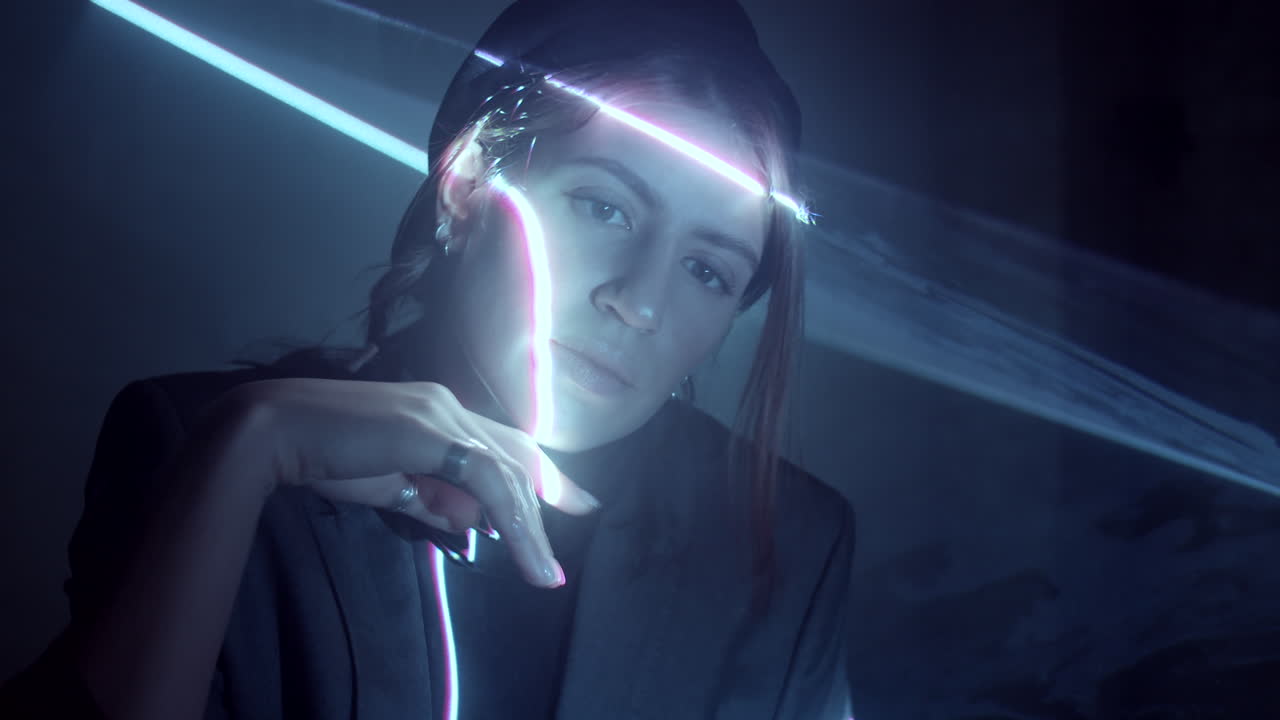 mujer tocando la proyección de luz láser en una habitación oscura