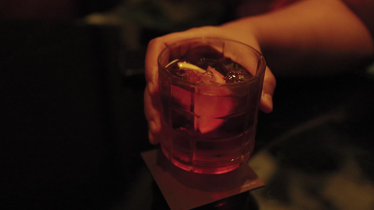 Mano che tiene un cocktail Negroni a Bangkok