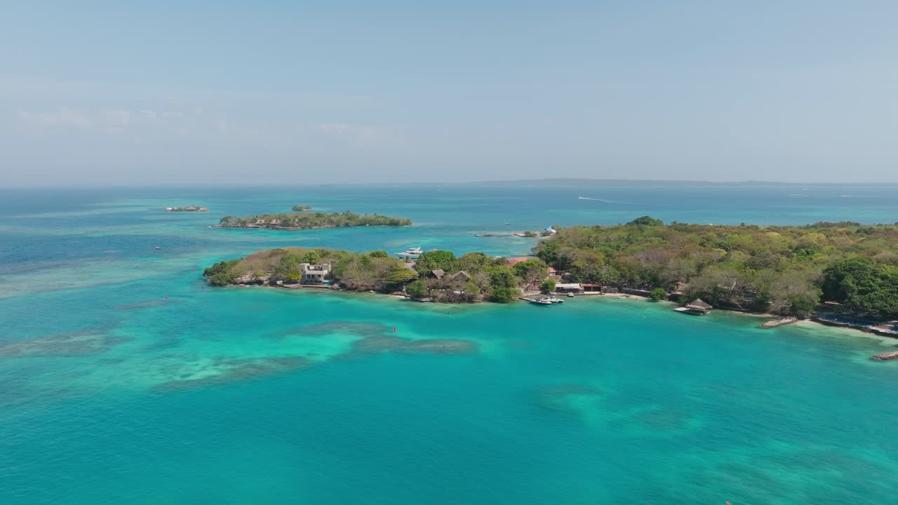 Drone view of Isla Grande in Rosario Islands, Colombia, surrounded by crystal clear Caribbean waters, coral reefs and lush tropical scenery