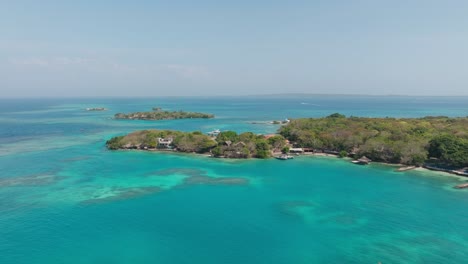 drone view of isla grande in rosario islands, colombia, surrounded by crystal clear caribbean waters, coral reefs and lush tropical scenery