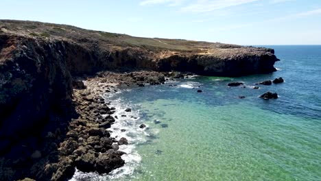 flying-over-the-green-water-at-cliffside-in-Portugal