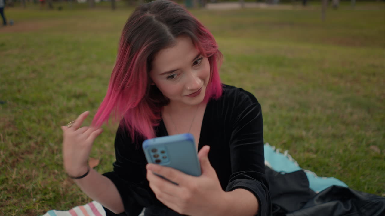 Giovane donna che si fa un selfie in un parco