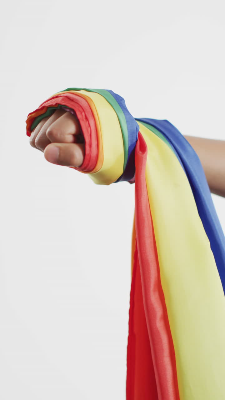 Vertical video of hand of caucasian man holding rainbow fabric