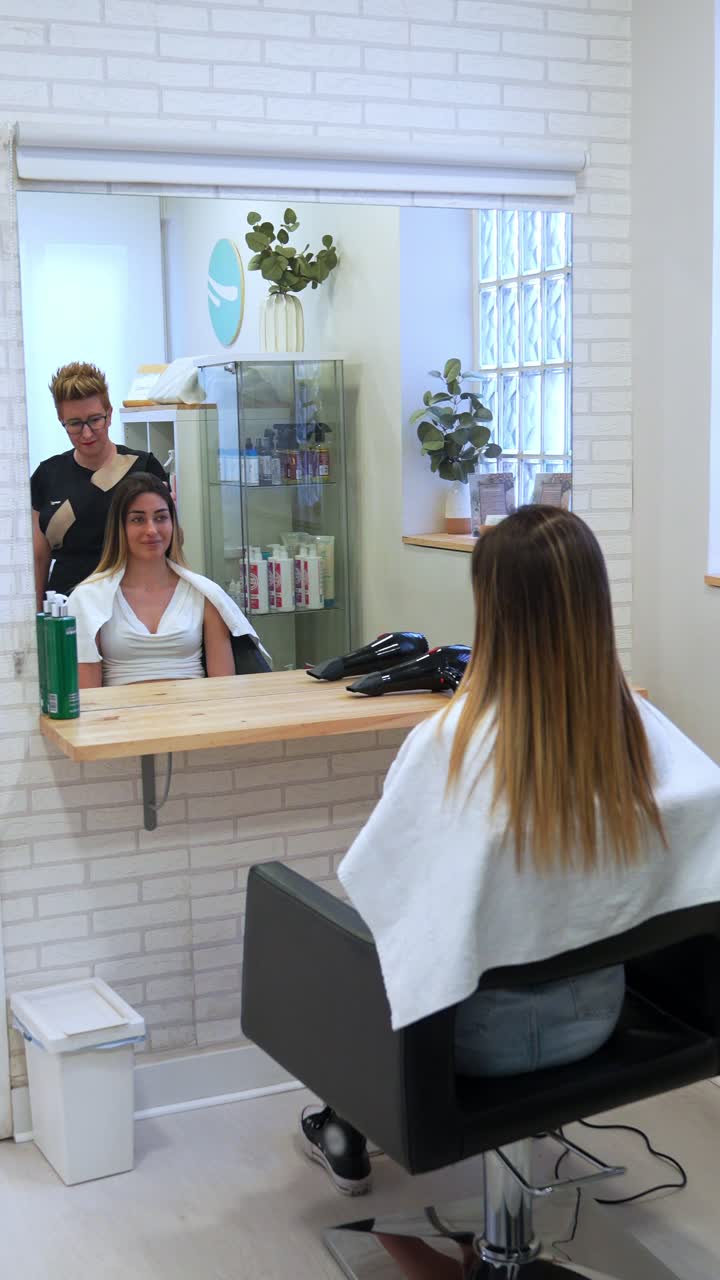 Cliente che si fa acconciare i capelli in un salone di parrucchieri