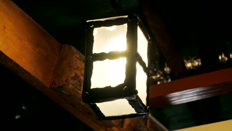 antique glowing lantern among wooden beams