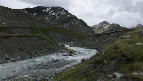 drone flying over waters stream flowing in valmalenco, italy