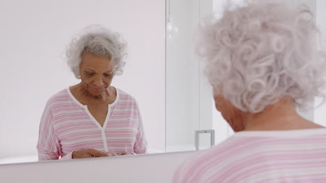 mujer mayor en el baño tomando pastillas de suplementos vitamínicos