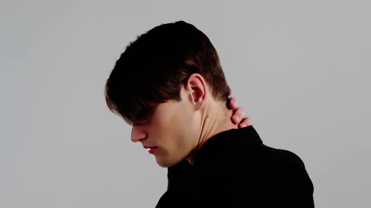 회색 배경을 배경으로 포즈를 취하는 남성