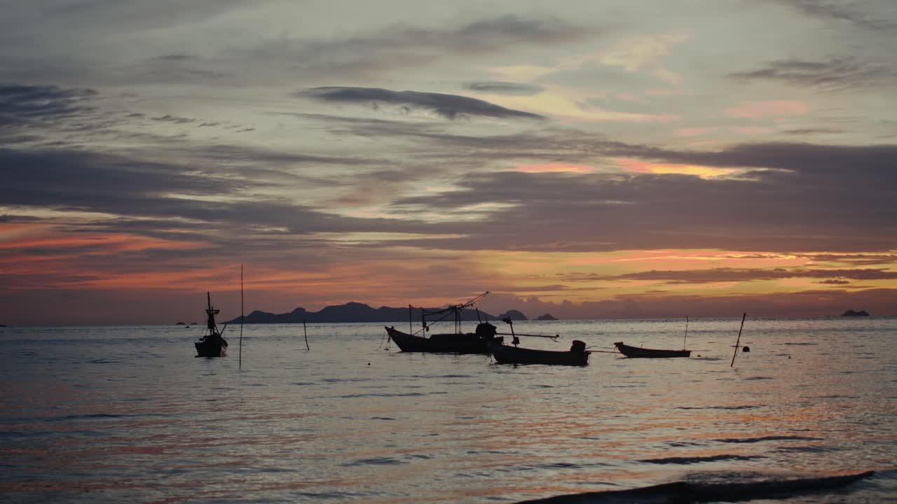 Sunset over the ocean with fishing boats