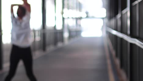 person performing jumping jacks in a corridor