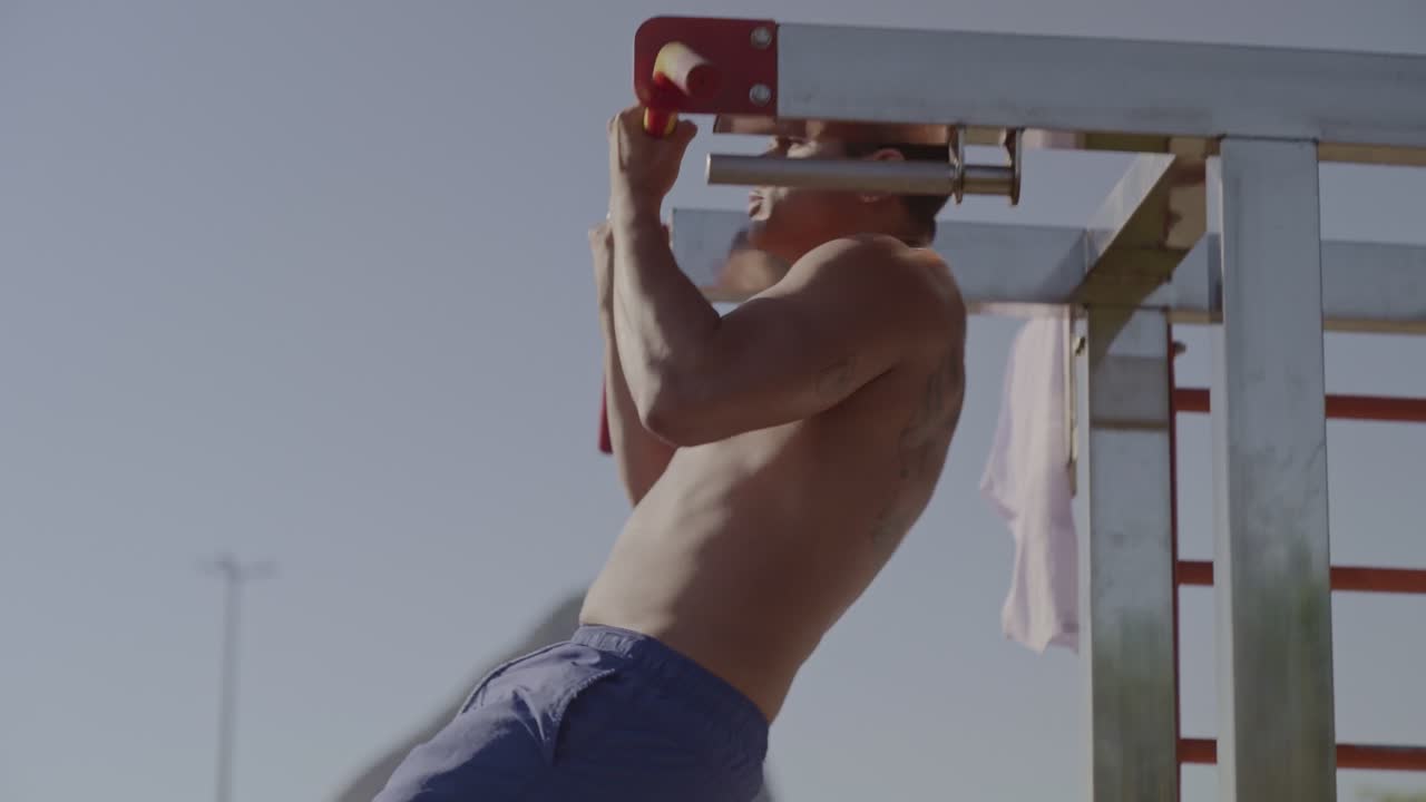 Man doing pull-ups on an outdoor bar