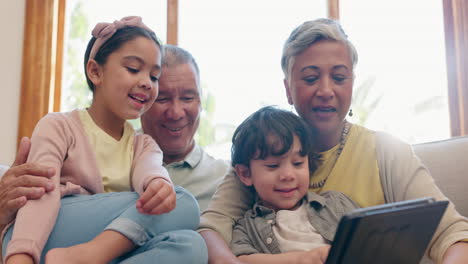 tablet, grandparents and children on sofa