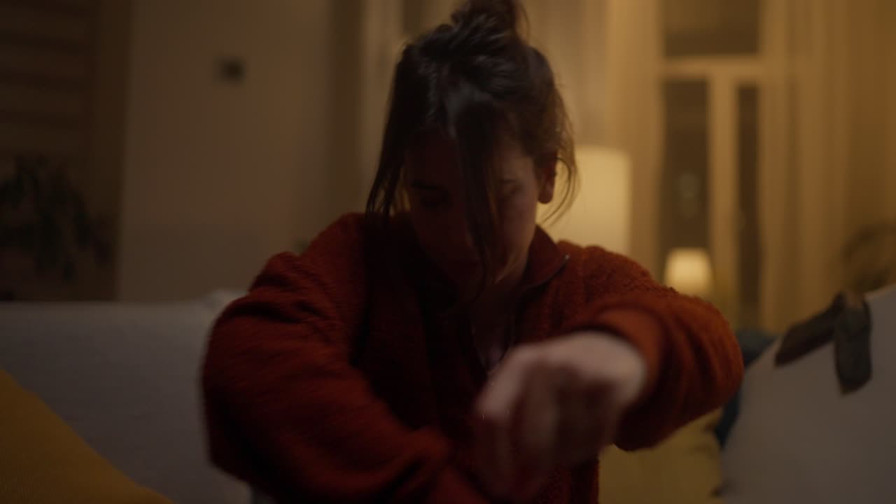 mujer sentada en un sofá abrazando una almohada