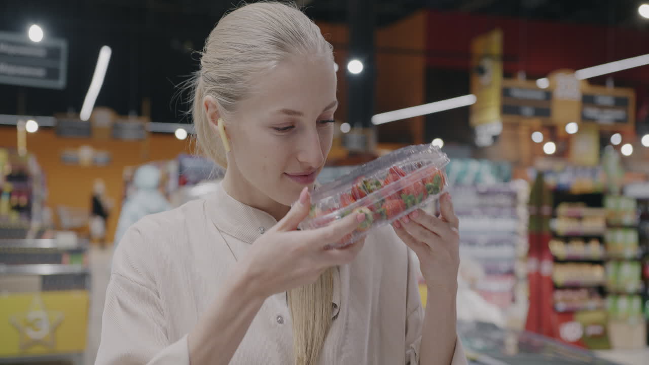 Woman Shopping for Strawberries in a Grocery Store
