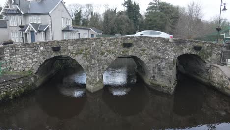 car driving through arch stone bridge in ballinodre, monaghan, ireland