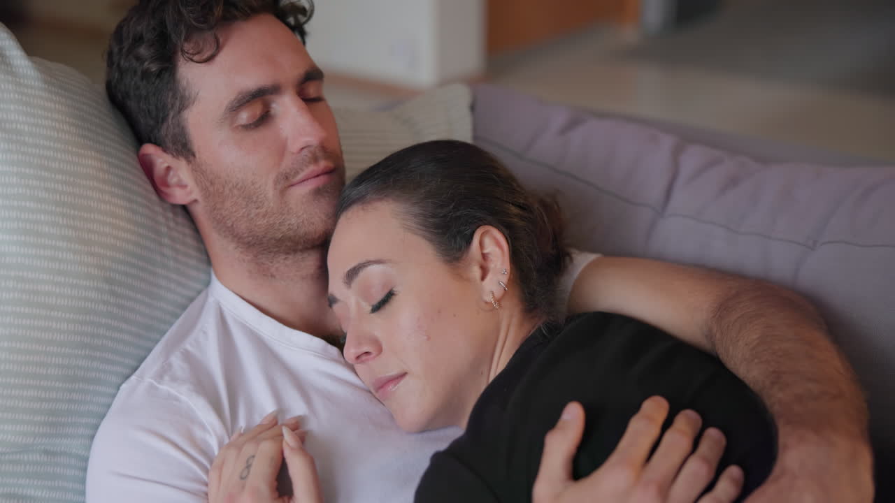 pareja, durmiendo y relajándose en el sofá juntos