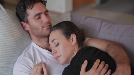 pareja, durmiendo y relajándose en el sofá juntos