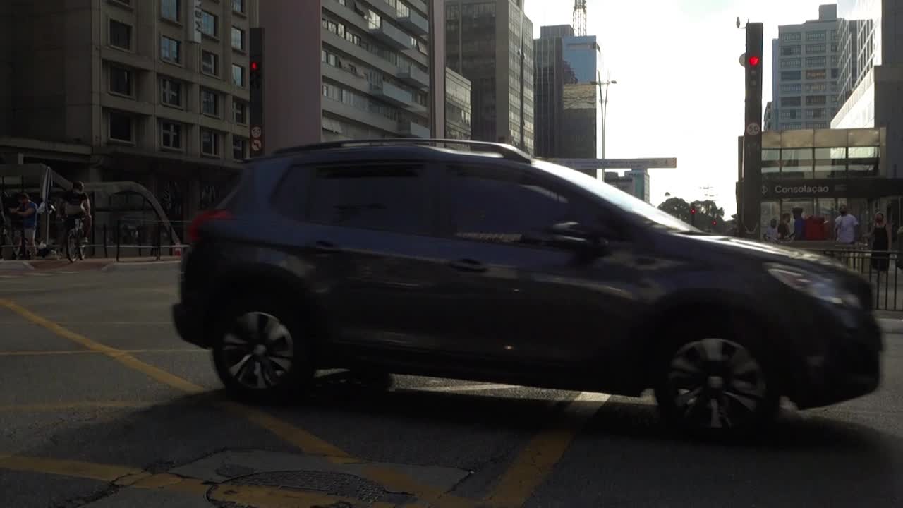 vehicle traffic on busy intersection at Paulista Avenue. Consolaçao subway entrance on the back