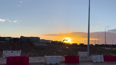 An-excavator-moving-towards-the-sunrise,-working-early-to-rebuild-the-city-of-Lisbon